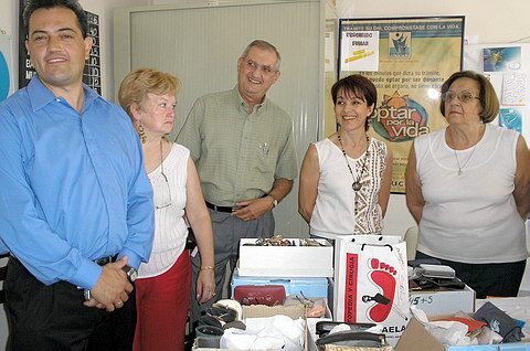 Integrantes del Rotary local junto a miembros de Alpi, durante la entrega. En las cajas, parte de lo reunido.