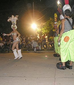 La batucada, vestidos de payasos, y la pasista, delante de ellos.