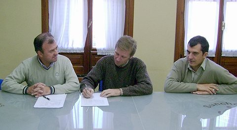 Los funcionarios y el secretario del gremio, suscribiendo el acuerdo.