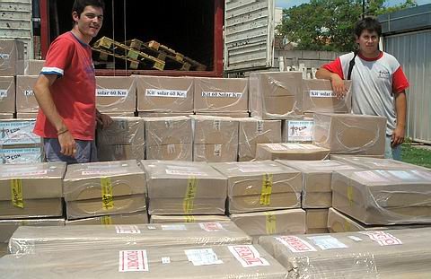 Dos de los jóvenes operarios, con la carga lista para ser preparada para el viaje a Venezuela.