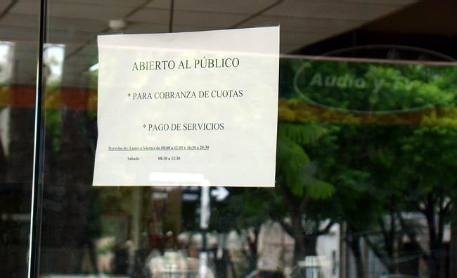 El cartel que notifica únicamente los cobros, detrás, sólo anaqueles vacíos.