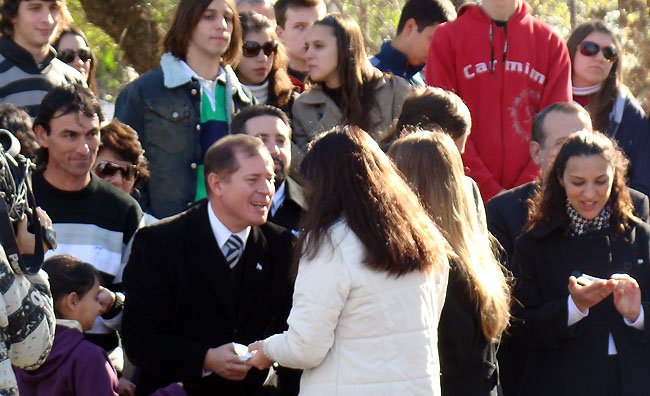 Trinchieri recibiendo una escarapela de la escuela organizadora del acto.