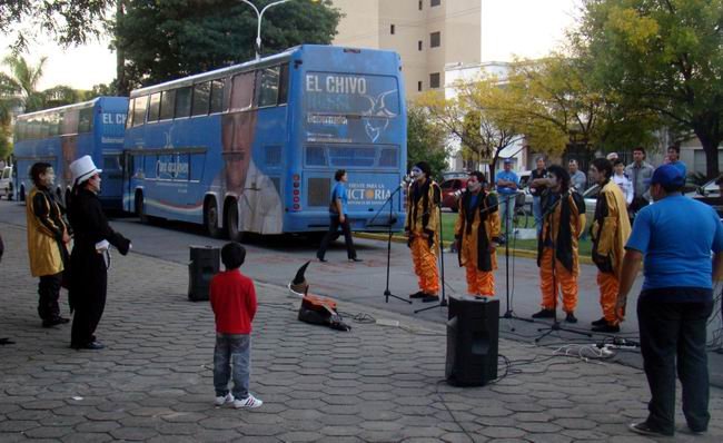 La murga actuando. Detrás, los micros de la Caravana Jóven.